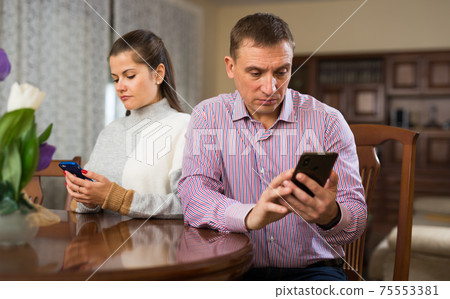 Man and his wife using phones 75553381