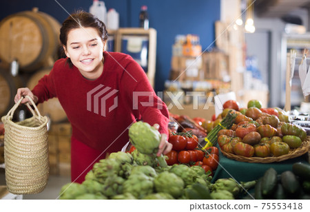 Teen girl decided to buy fresh artichoke 75553418