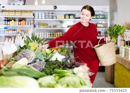 Girl looking at assortment of vegetables 75553425