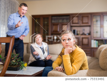Portrait of upset girl scolded by parents at home Portrait of upset girl scolded by parents at home 75553491