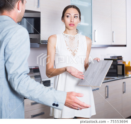 Outraged girl communicating with seller of kitchen Outraged girl communicating with seller of kitchen 75553694