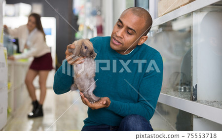 Portrait of man holding rabbit in hands 75553718
