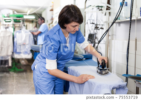 Female laundry worker ironing 75553719