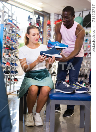 woman customer trying sports shoes woman customer trying sports shoes 75553757