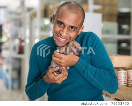 Portrait of man holding rabbit in hands 75553760