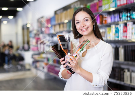 Young woman demonstration combs for hair at the supermarket Young woman demonstration combs for hair at the supermarket 75553826