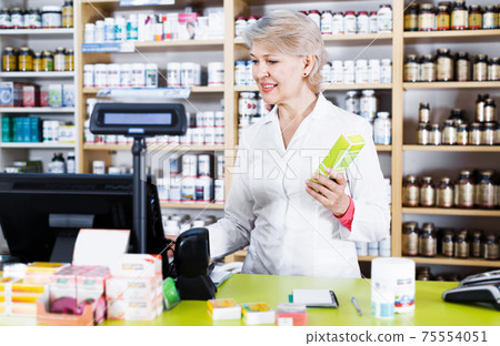 Woman checking assortment of care products for body 75554051