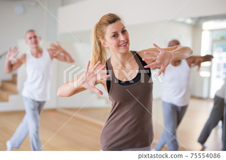 Woman dancing at group lesson in studio Woman dancing at group lesson in studio 75554086