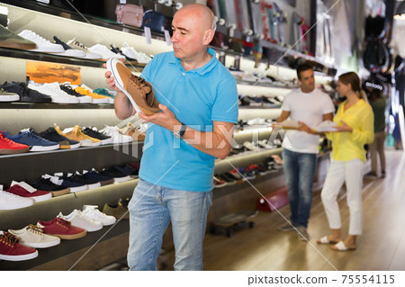 Adult man looking for new casual shoes Adult man looking for new casual shoes 75554115