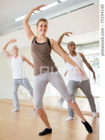 Young woman practicing ballet moves in choreographic studio Young woman practicing ballet moves in choreographic studio 75554140