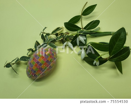 Colorful Easter egg and spring flowers on a yellow background. Easter greeting, postcard, copy space, easter decorations 75554530