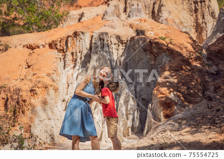Mom and son tourists on the Fairy stream among the red dunes, Muine, Vietnam. Vietnam opens borders after quarantine COVID 19 75554725