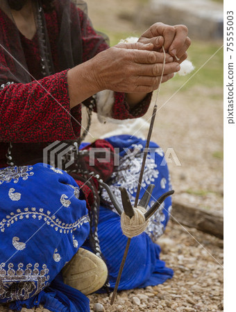 Iranian Hill Tribe Woman Spins Goat Wool - Close-up Iranian Hill Tribe Woman Spins Goat Wool - Close-up 75555003