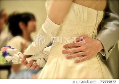 Groom's hand escorting the bride with a wedding cake cut 75555672
