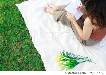 woman alone resting on a picnic in nature park outside at sunny day  enjoying summertime and dreaming woman alone resting on a picnic in nature park outside at sunny day  enjoying summertime and dreaming 75557712