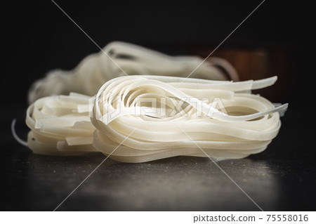 Dried white rice noodles. Raw pasta. Uncooked noodles. 75558016