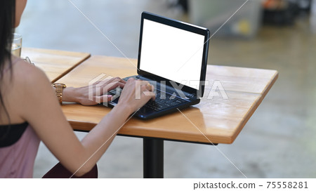 Behind shot of beautiful woman is working with a white blank screen computer laptop at the wooden desk. Behind shot of beautiful woman is working with a white blank screen computer laptop at the wooden desk. 75558281