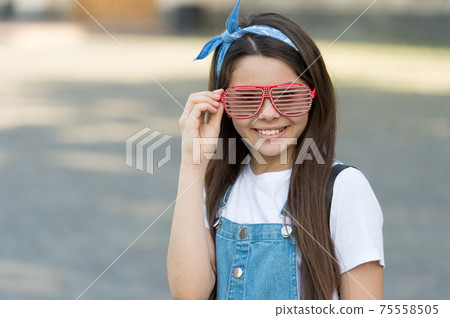 Smiling fashionable teen girl with headband and sunglasses, summer party concept Smiling fashionable teen girl with headband and sunglasses, summer party concept 75558505