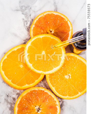 Vitamin C serum bottle with dropper on white marble background Vitamin C serum bottle with dropper on white marble background 75559373