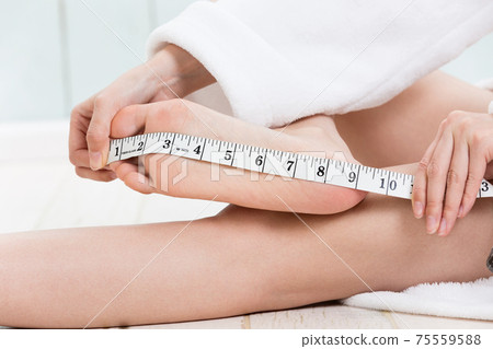 Woman measuring the sole of the foot Woman measuring the sole of the foot 75559588