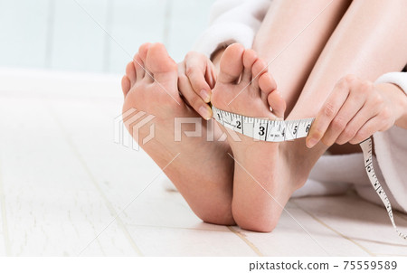 A woman measuring the size of the instep A woman measuring the size of the instep 75559589