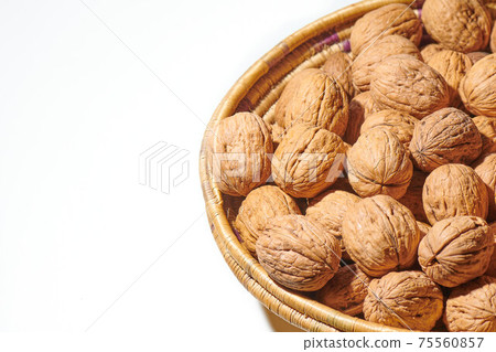 Walnuts in a basket on a white background 75560857