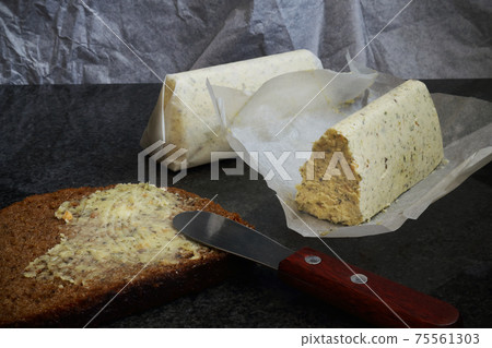 Herb cheese and garlic compound butter with rye bread and small butter knife Herb cheese and garlic compound butter with rye bread and small butter knife 75561303