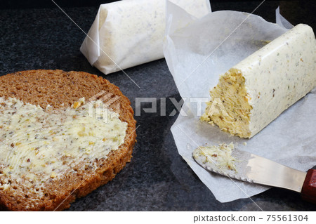 Homemade compound butter with bread and knife on black marble Homemade compound butter with bread and knife on black marble 75561304