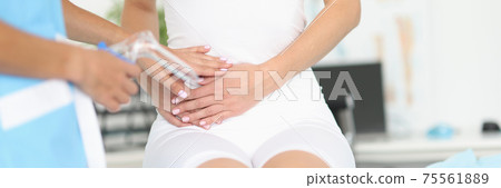 Gynecologist consult patient in clinic with his pain in lower abdomen. 75561889