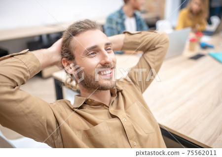 Handsome young bearded guy sitting in the office Handsome young bearded guy sitting in the office 75562011