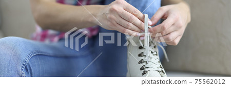 Woman tying shoelaces on new demi leather boots. Woman tying shoelaces on new demi leather boots. 75562012