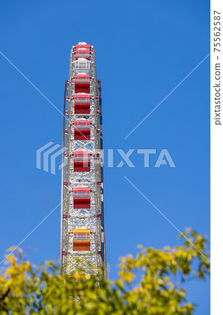 Red gondola ferris wheel and blue sky 75562587