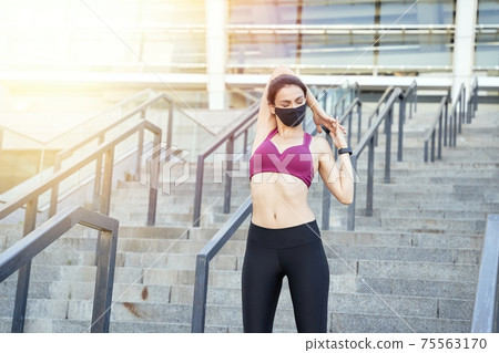 Pretty lady in the top doing warm-up before jogging Pretty lady in the top doing warm-up before jogging 75563170