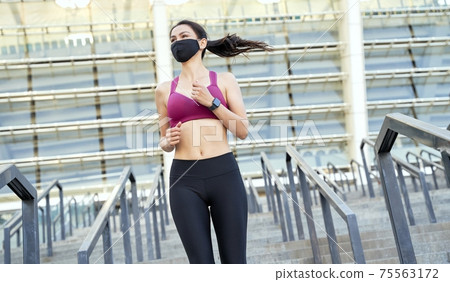 Young lady in sports top and leggings jogging Young lady in sports top and leggings jogging 75563172