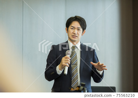 A businessman talking with a microphone 75563210