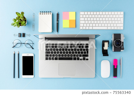 Modern workspace concept with laptop and business accessories on blue background. Office desktop. Top view 75563340