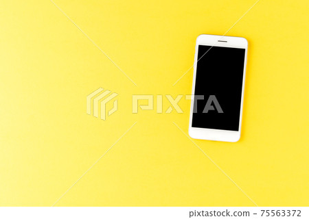 Smart phone on yellow background. Top view 75563372