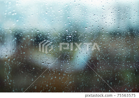 Rain drops on window glass surface. Rainy spring background Rain drops on window glass surface. Rainy spring background 75563575