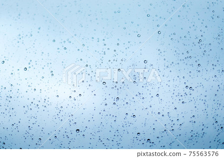 Rain drops on window glass surface. Rainy spring background Rain drops on window glass surface. Rainy spring background 75563576