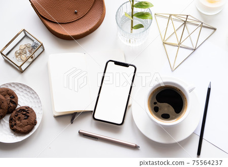 White home office tabletop with smartphone mock-up, coffee cup and notepad White home office tabletop with smartphone mock-up, coffee cup and notepad 75564237