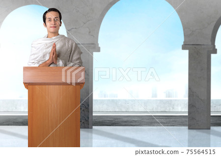 Asian Muslim man in ihram clothes standing with greeting gesture Asian Muslim man in ihram clothes standing with greeting gesture 75564515
