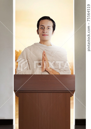 Asian Muslim man in ihram clothes standing with greeting gesture 75564519