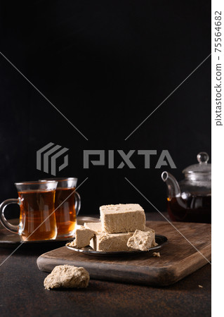 Tea ceremony with halva on dark. Close up. Tea ceremony with halva on dark. Close up. 75564682