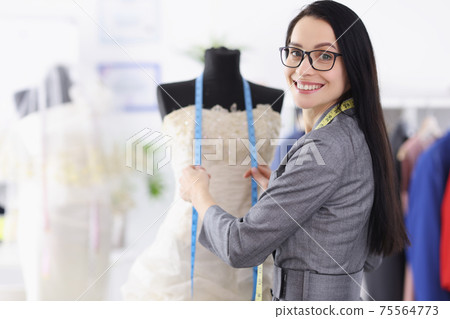 Portrait of young woman seamstress in wedding salon Portrait of young woman seamstress in wedding salon 75564773