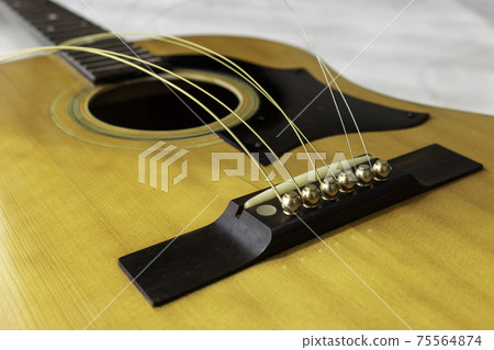 Image of exchanging strings on an acoustic guitar 75564874