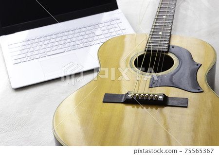 Image of exchanging guitar strings while looking at a computer Image of exchanging guitar strings while looking at a computer 75565367