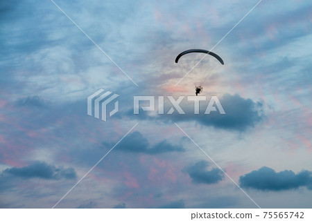 paramotor flight in horizontal sunset sky paramotor flight in horizontal sunset sky 75565742
