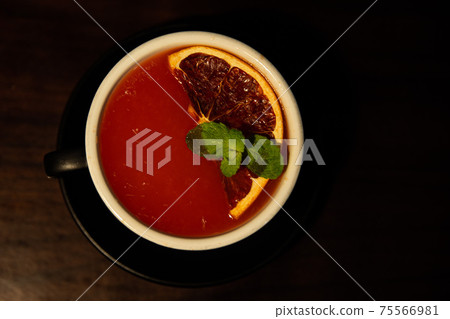Red grapefruit tea with grapefruit in a black mug Red grapefruit tea with grapefruit in a black mug 75566981