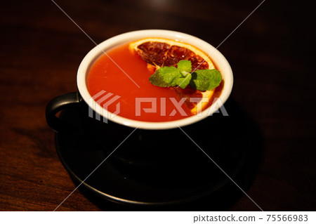 Red grapefruit tea with grapefruit in a black mug Red grapefruit tea with grapefruit in a black mug 75566983