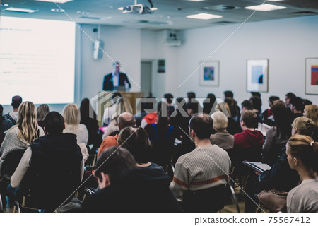 Man giving presentation in lecture hall at university. 75567412
